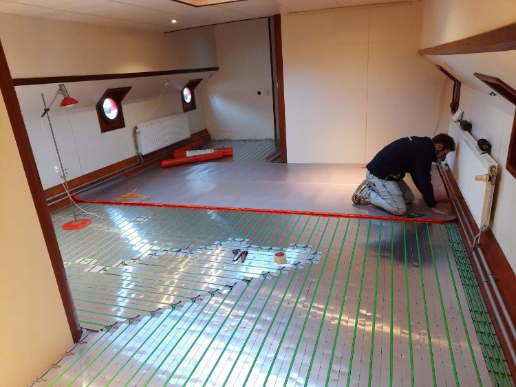 Man legt vloerverwarming in woonschip